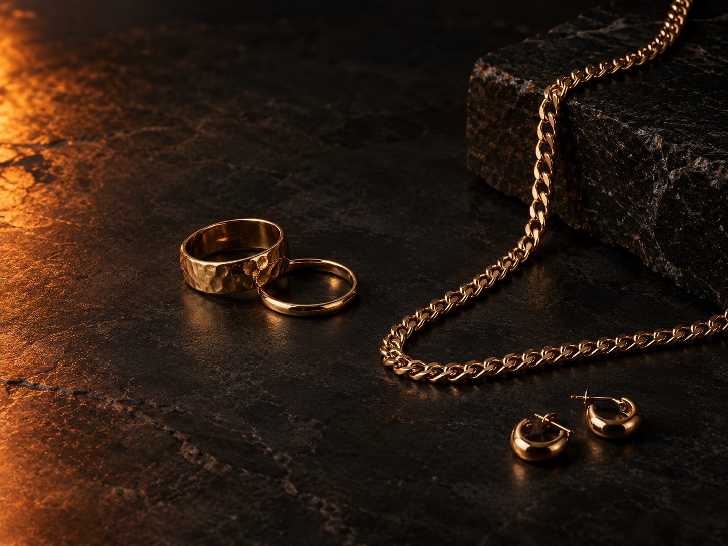 Sélection éditoriale de bijoux dorés sur pierre sombre